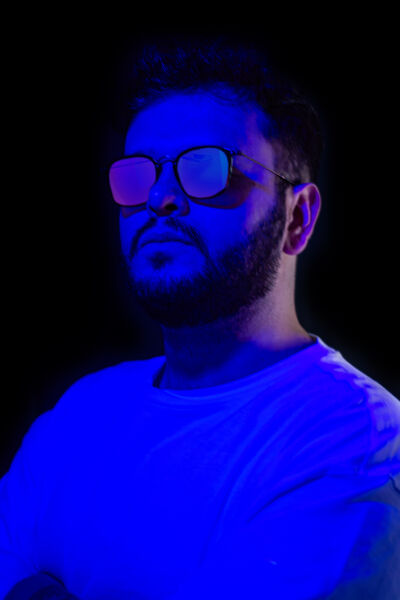 Silhouetted DJ performs on stage with vibrant neon lights