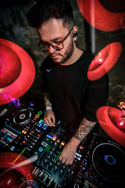 DJ in an energetic performance during a colorful night concert